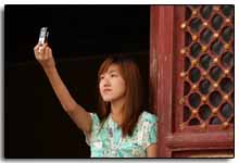 une asiatique se prend en photo avec son téléphone