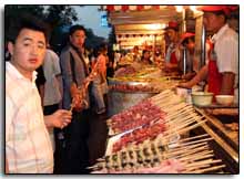 un Chinois tient une brochette de poulpe à la main