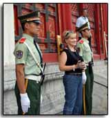 une touriste occidentale se fait prendre en photo devant deux gardes Rouges chinois